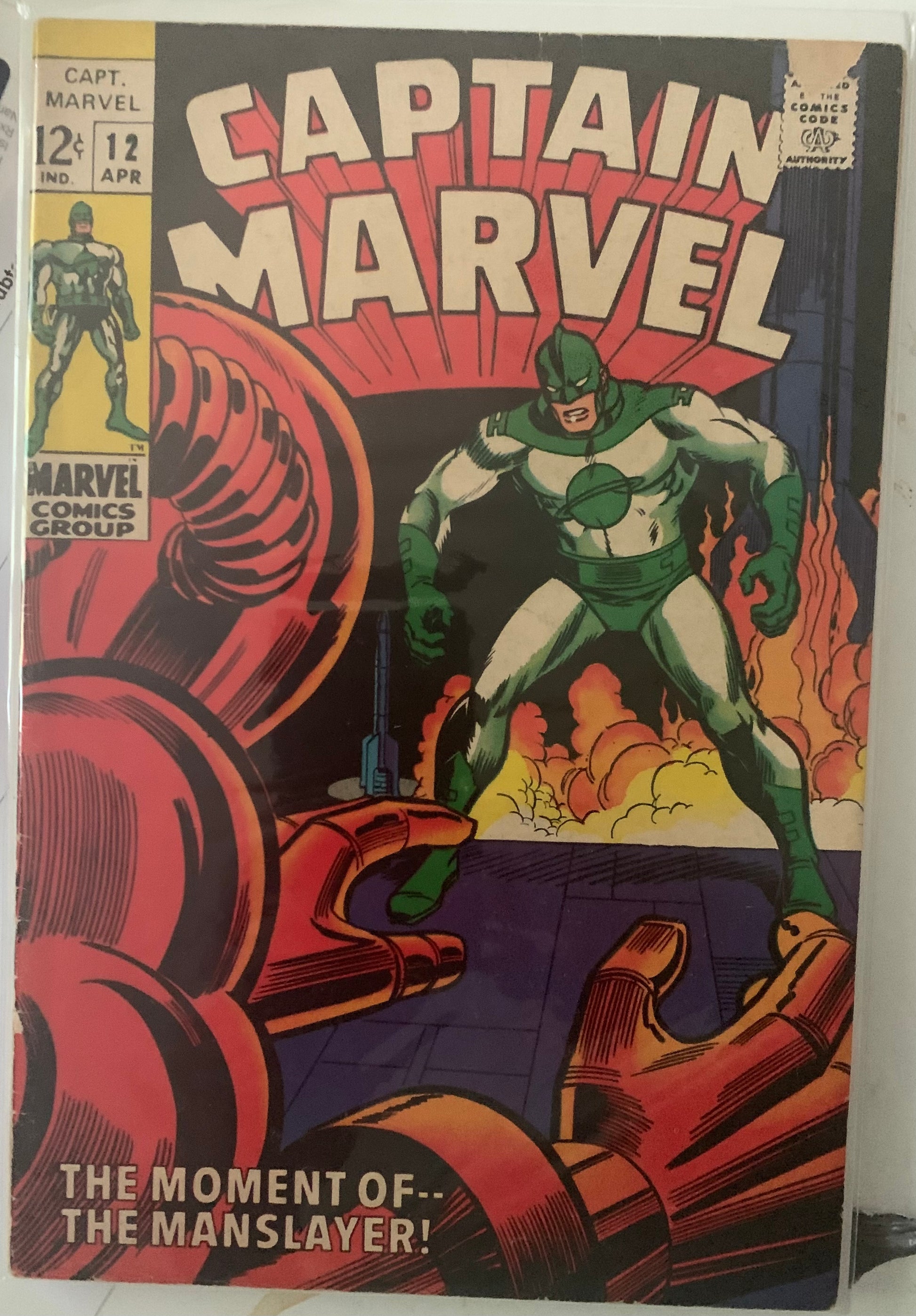 Vintage comic book cover featuring Captain Marvel with character in a red space suit in a dramatic fire background