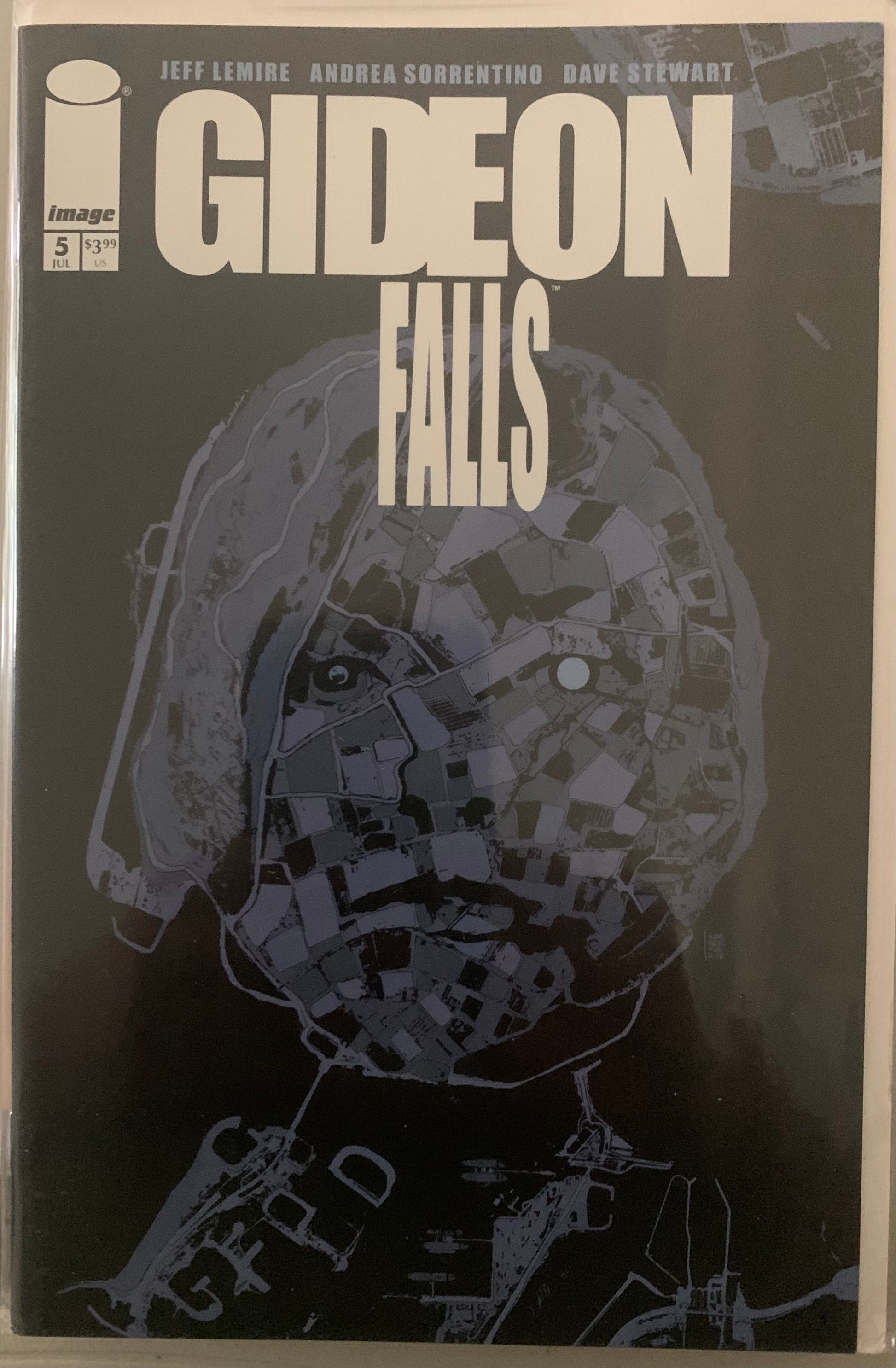 Comic book cover of 'Gideon Falls' with a areal shot in the form of a female figure on a dark background