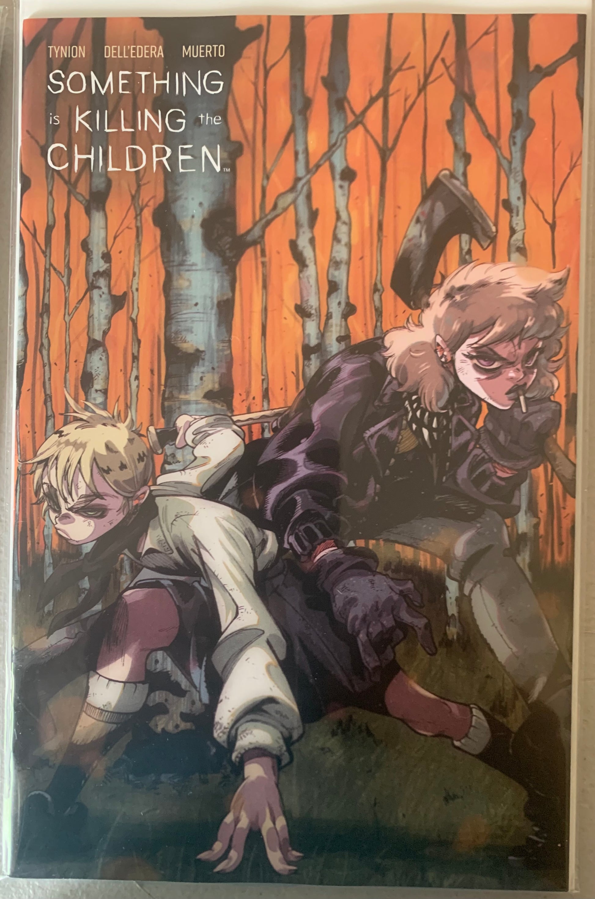 Comic Book cover of 'Something is Killing the Children' with two characters with an axe and a knife in a tense forest setting