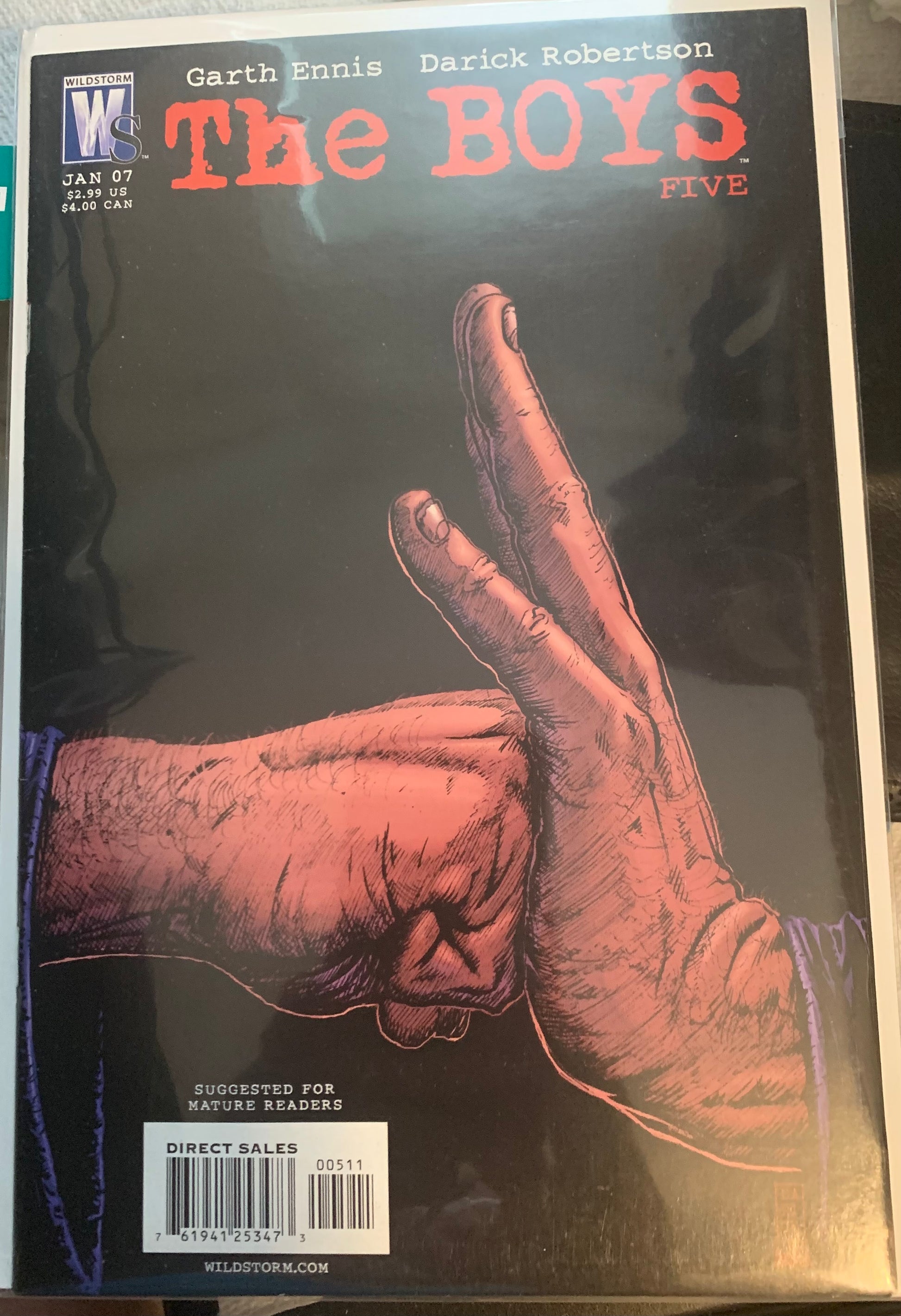 Comic book cover of 'The Boys' with a fist hitting an open palm on a dark background