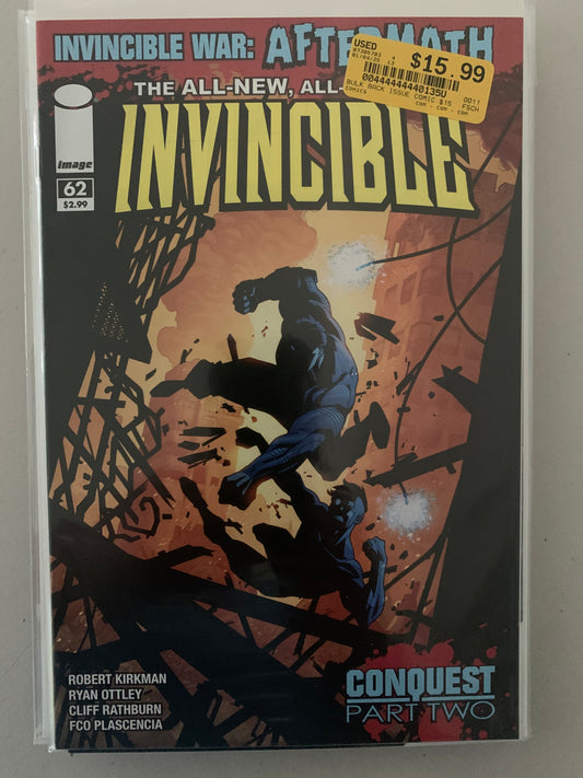 Comic book cover titled 'Invincible' fighting Conquest with destroyed buildings in the background. 